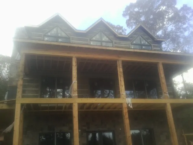Dormers and porch framing on a large log home under construction — Roof Coating work by our crew in Keller