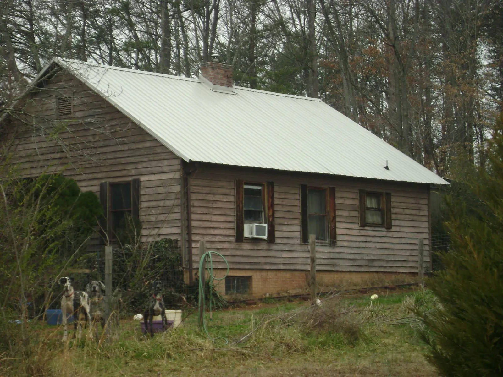 White metal roof on an old wood sided farmhouse, from a Metal Roof Installation job in Keller